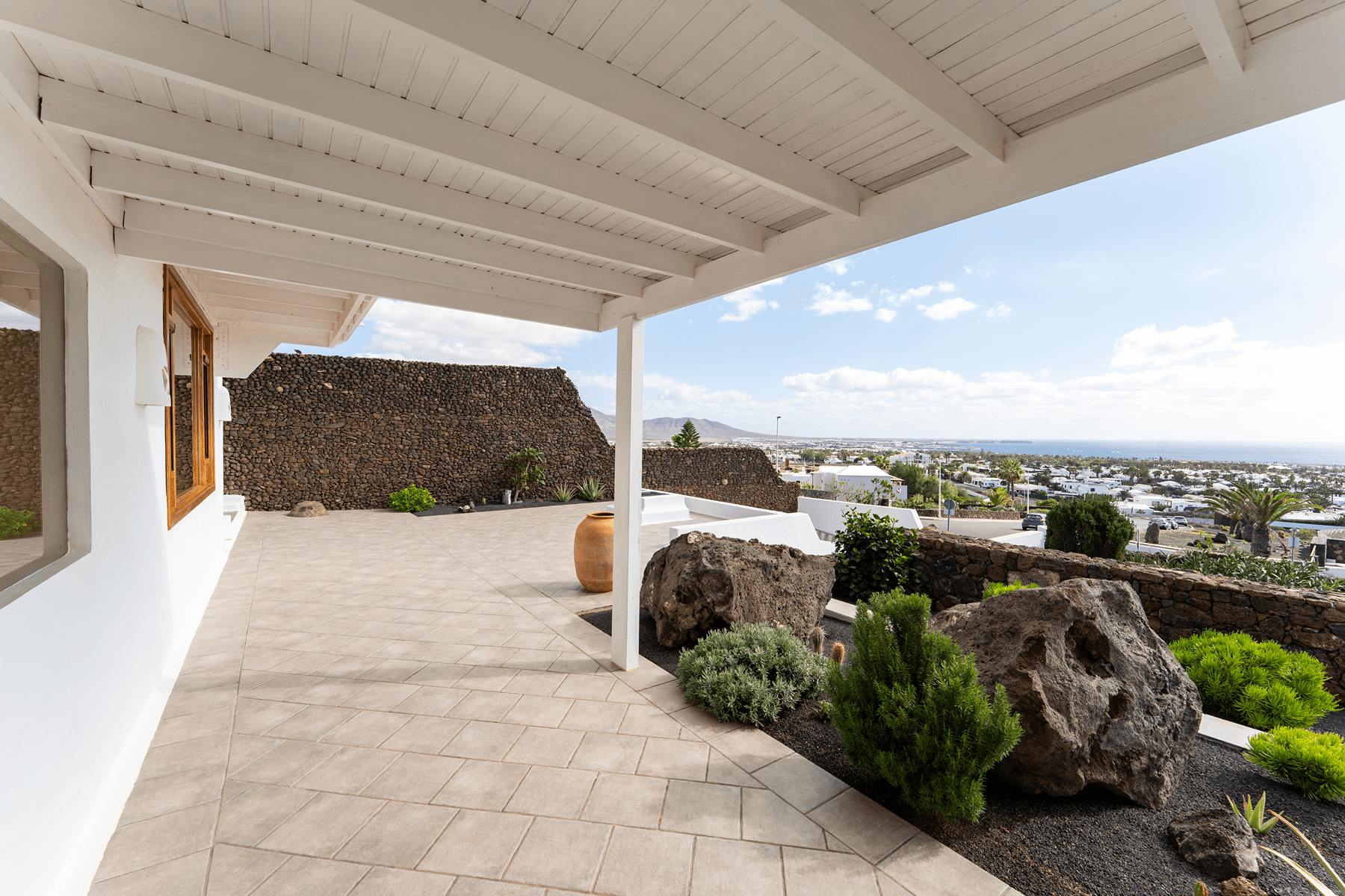Porche cubierto con vistas al océano y jardín volcánico en Lanzarote