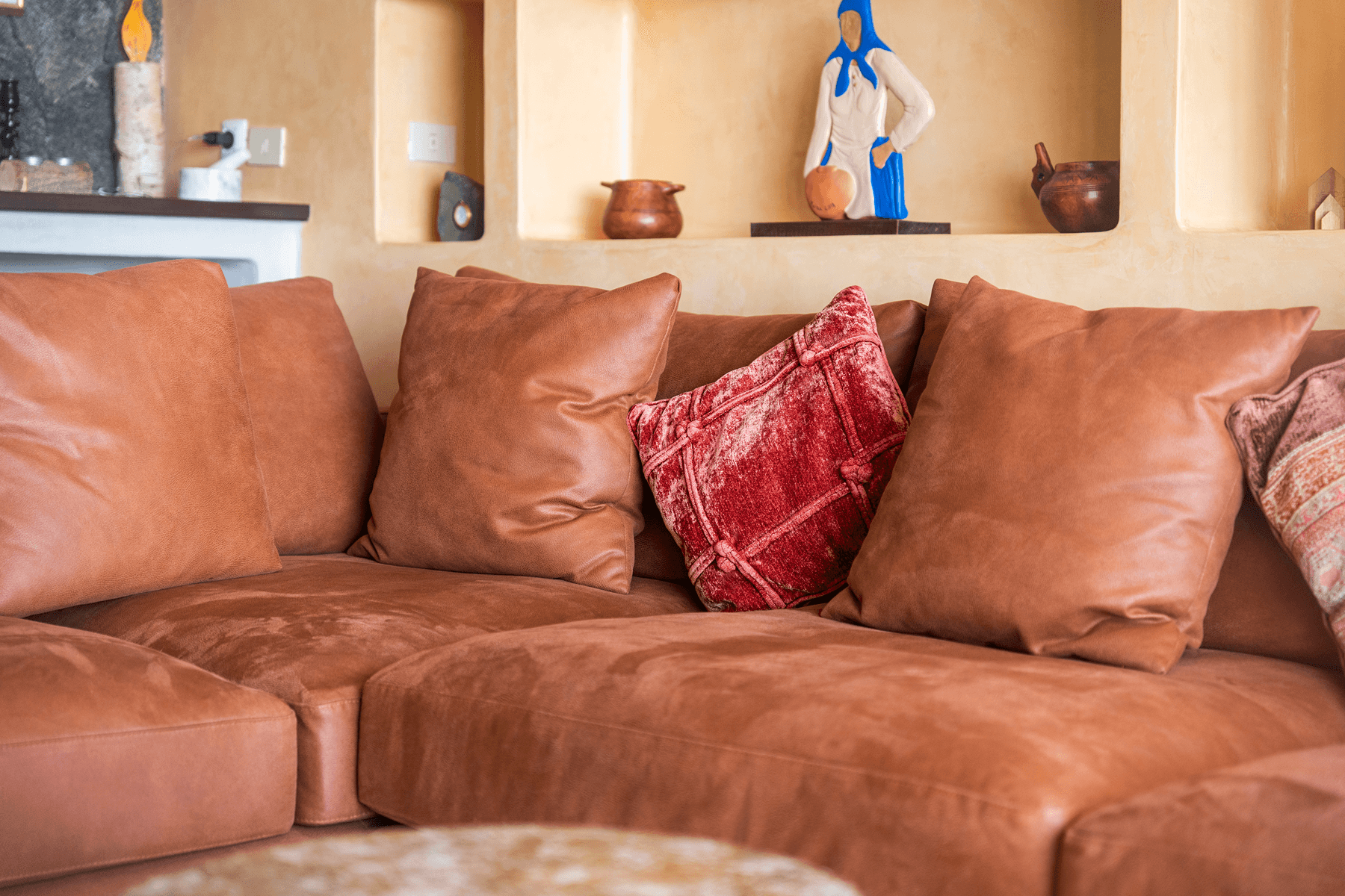 Sofá de piel con cojines y decoración artesanal en salón de villa Lanzarote