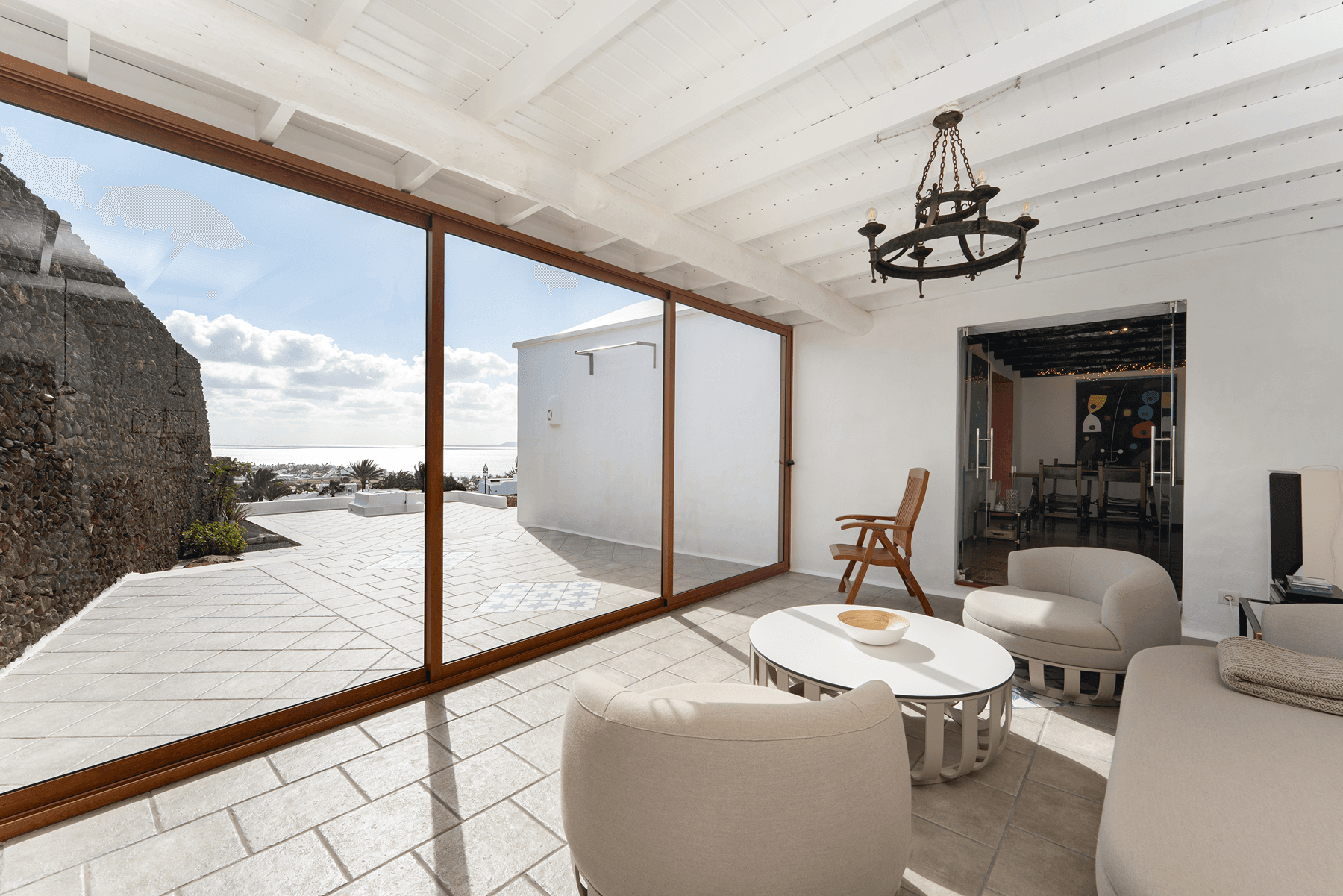 Terraza cubierta con vistas al mar y salón contiguo en villa de lujo Lanzarote